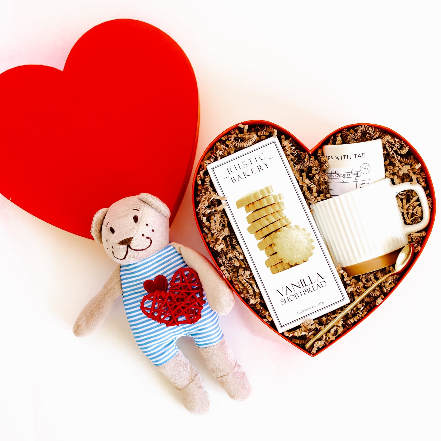 Valentine’s Day heart-shaped gift box with vanilla cookies, oolong tea sachets, ceramic mug, gold spoon, and teddy bear