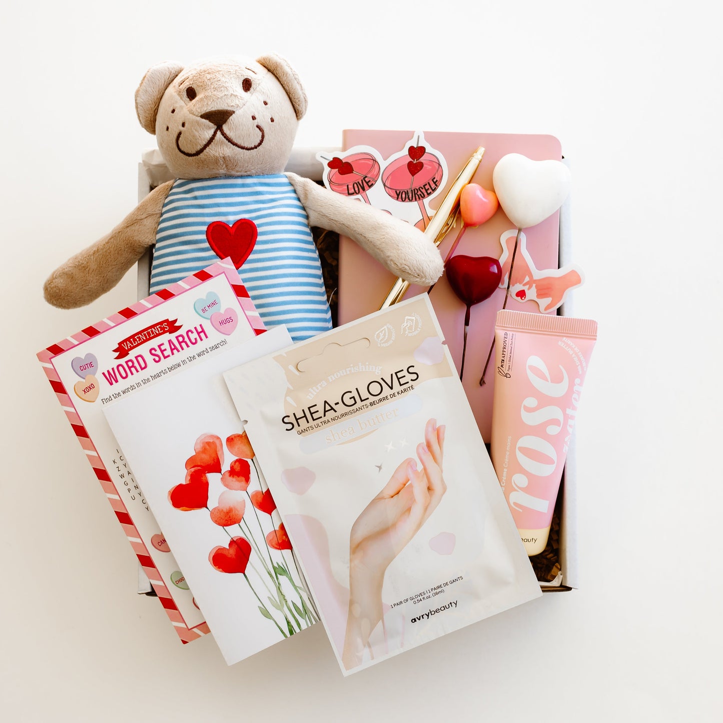 Valentine’s self-care gift box with teddy bear, rose hand lotion, hand mask gloves, notebook with gold pen, word game, and personalized love-themed card
