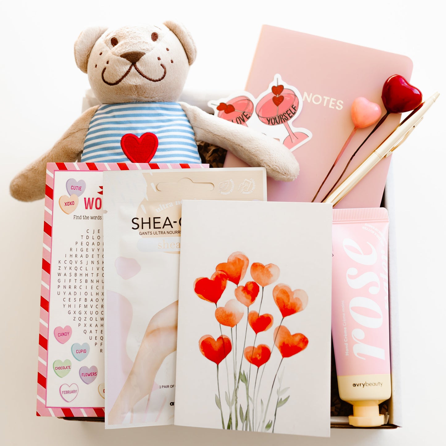Valentine’s self-care gift box with teddy bear, rose hand lotion, hand mask gloves, notebook with gold pen, word game, and personalized love-themed card