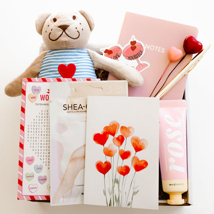 Valentine’s self-care gift box with teddy bear, rose hand lotion, hand mask gloves, notebook with gold pen, word game, and personalized love-themed card